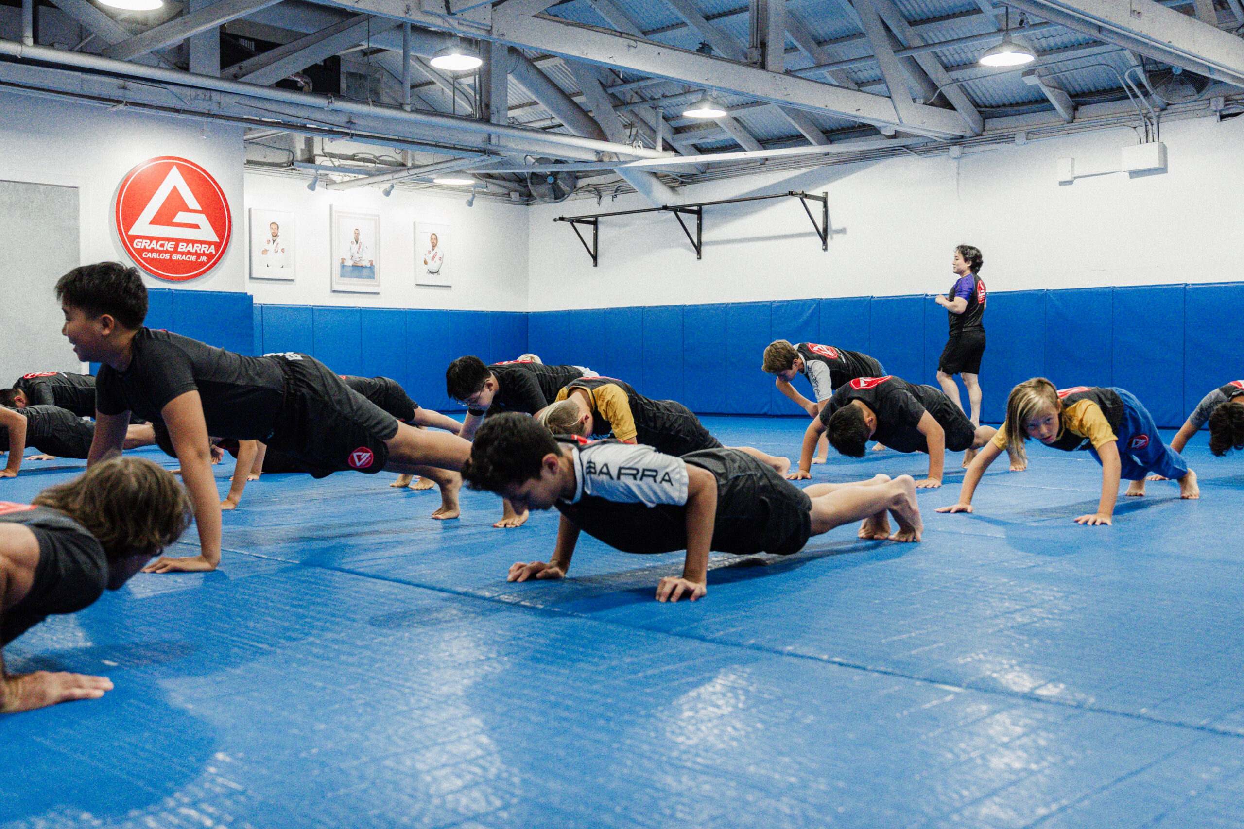 Youth students participating in structured mat warm ups during an active family jiu jitsu program.